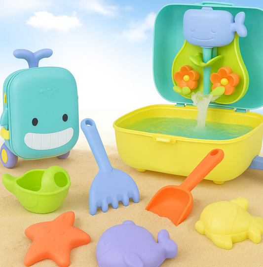 valise de jeux de plages posée sur le sable avec pelles et moules à sable