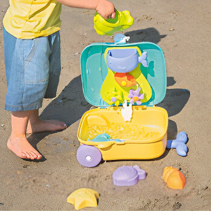 Enfant jouant sur la plage avec un set de sable en valise – moules d’animaux et jeu d’eau éducatif