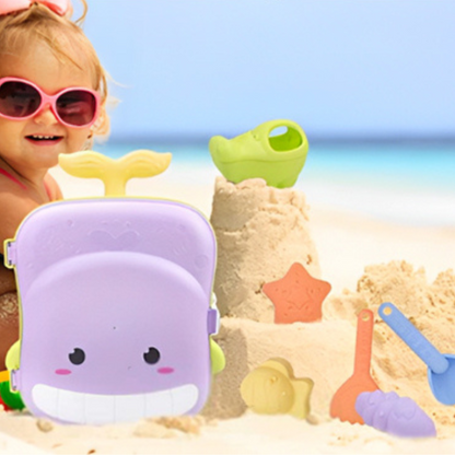 Petite fille jouant sur la plage avec un set de sable en valise baleine – accessoires ludiques et moules colorés